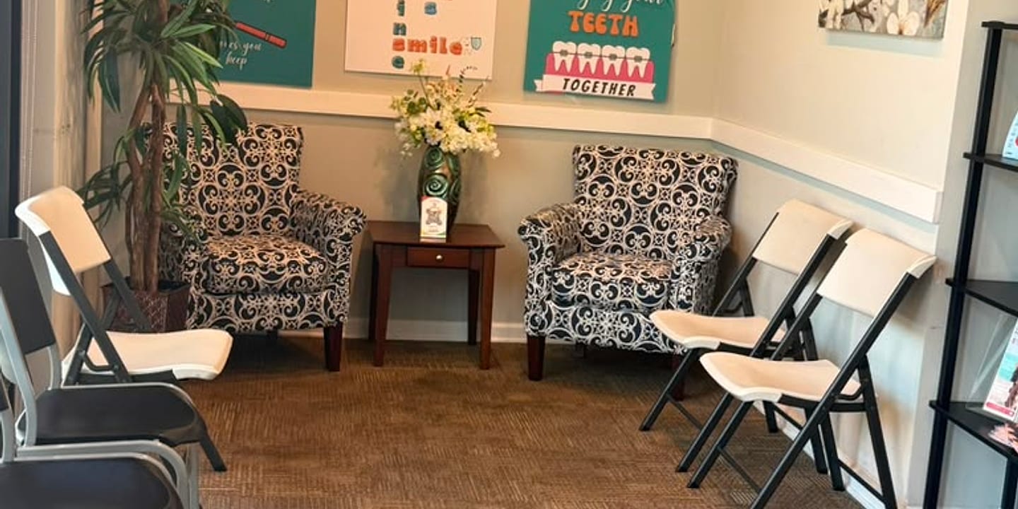 Waiting area at Dentist at Saluda Pointe with armchairs and dental-themed wall art